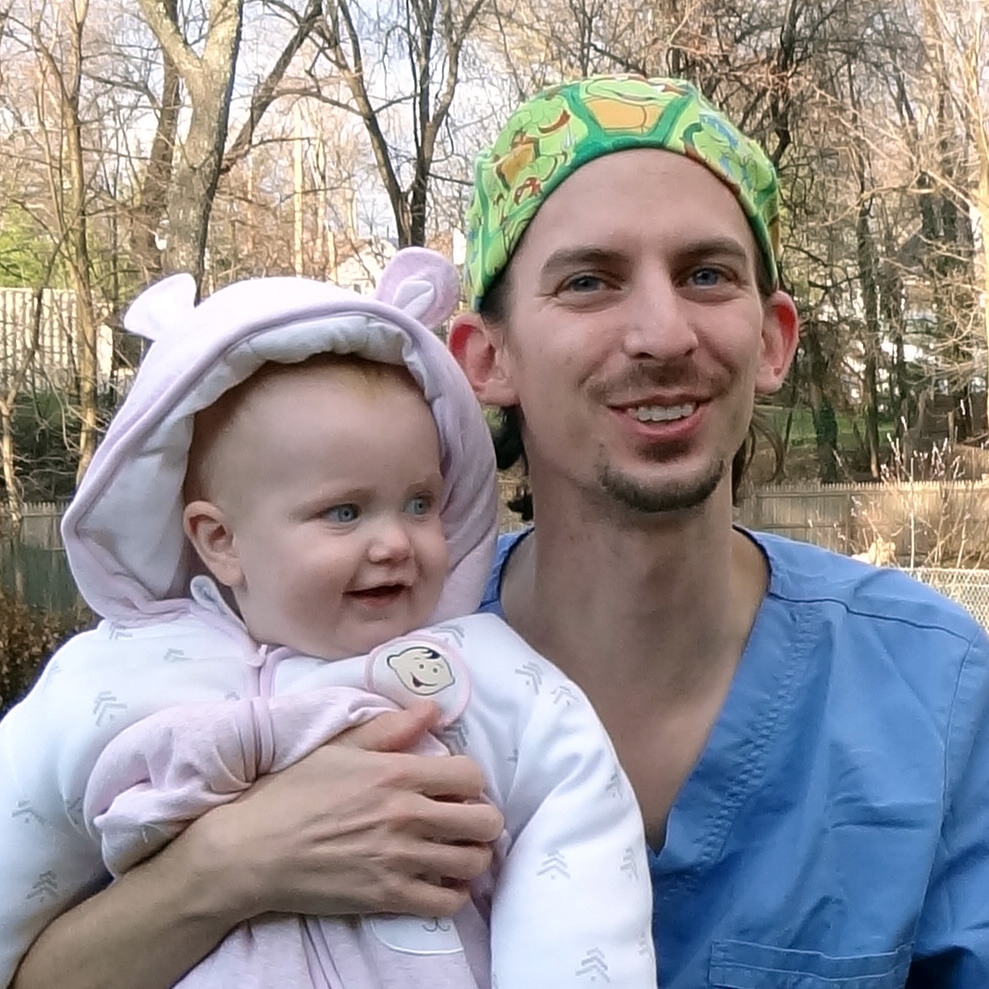 Jordan Arndts, a Drexel nursing student, holds a young child and smiles at the camera